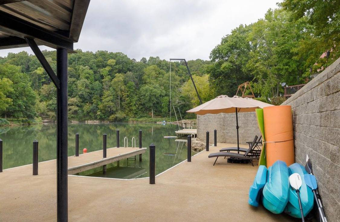 Dock with kayaks, lounge chairs and umbrella overlooking the lake
