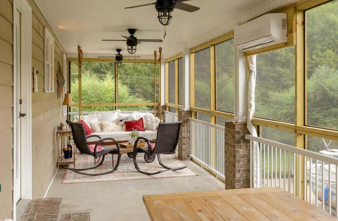 Screened porch with hanging daybed, rocking chairs and lake views