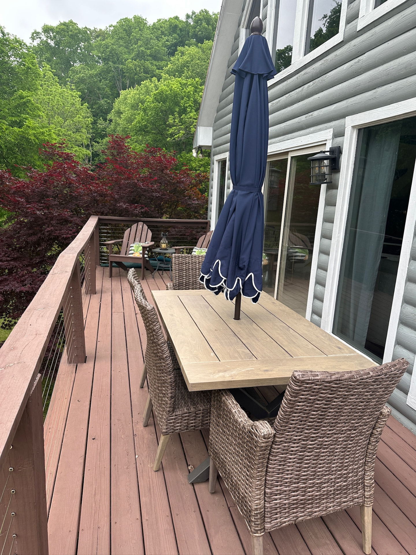 Outdoor dining area on the deck with umbrella and lake views