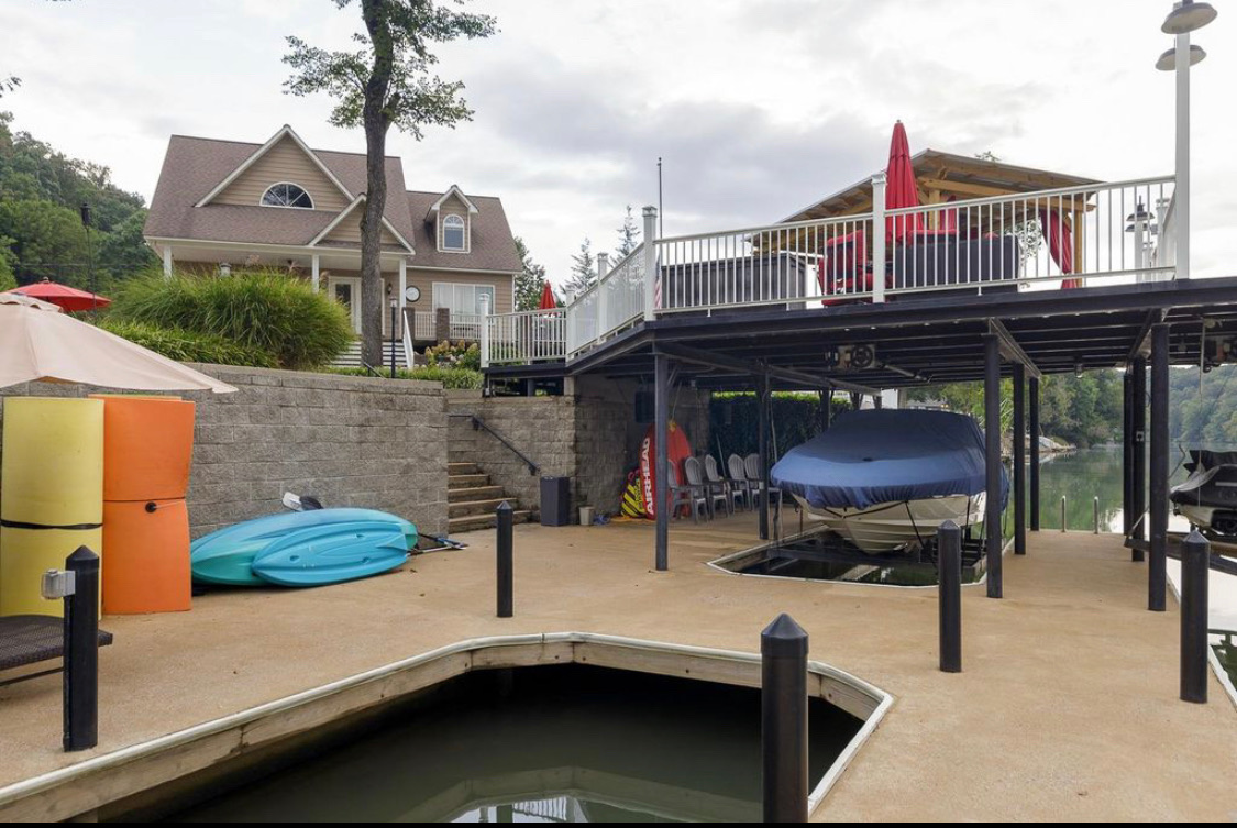 Dock and boathouse with house, covered boat and kayaks