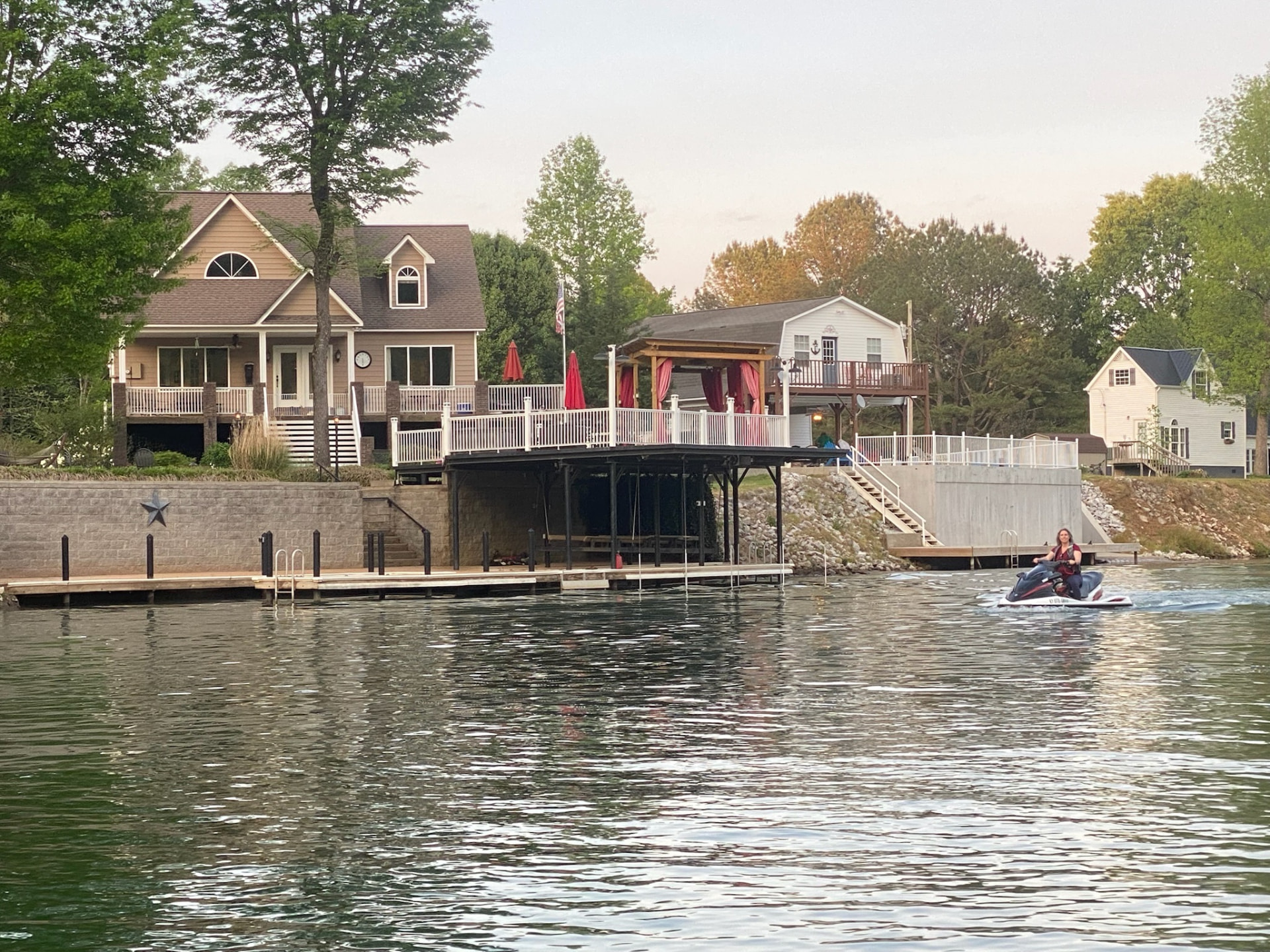 Waterfront view of both houses, dock and jet ski on the lake