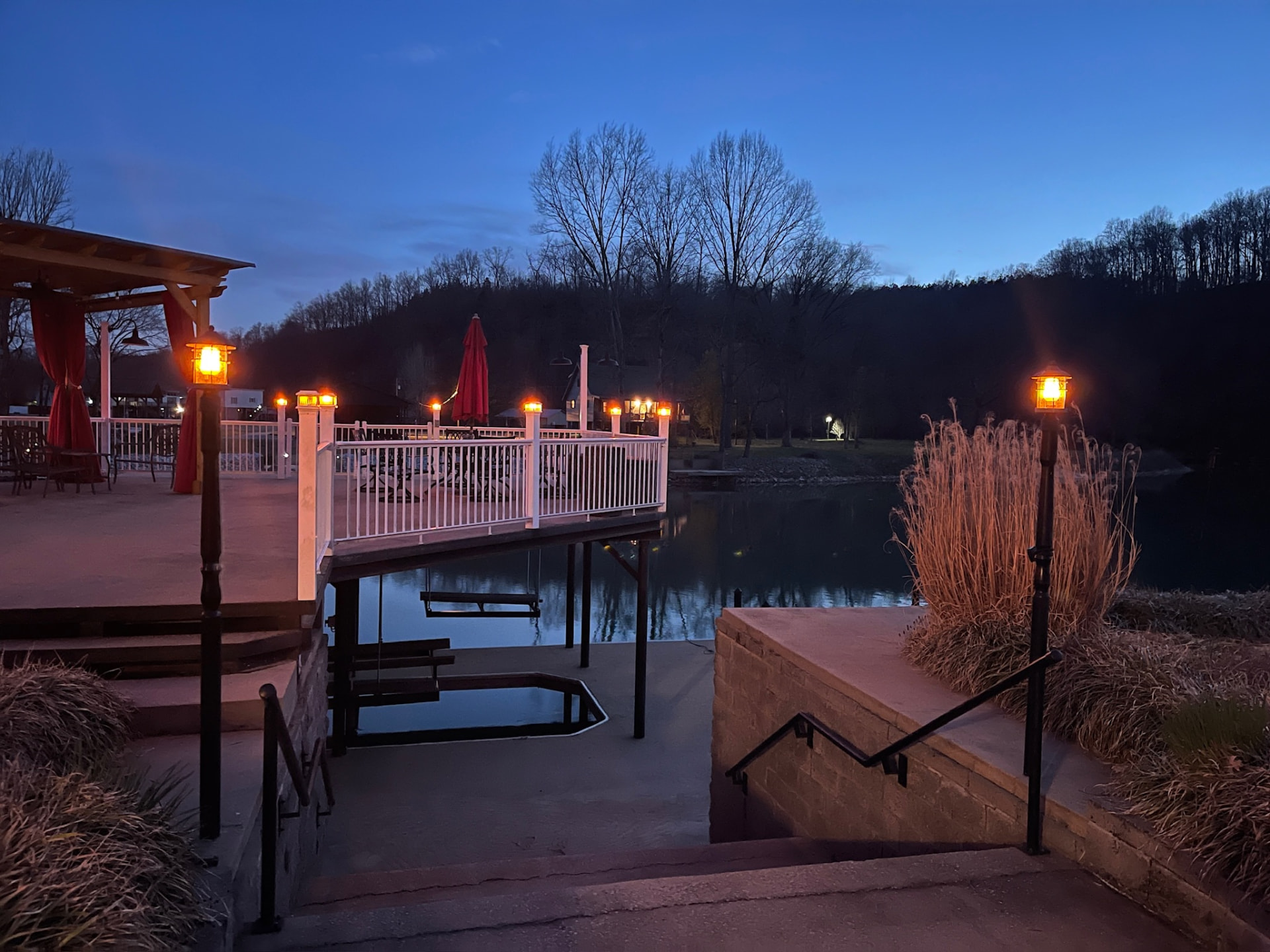 Evening view of the dock pavilion lit by warm post lights