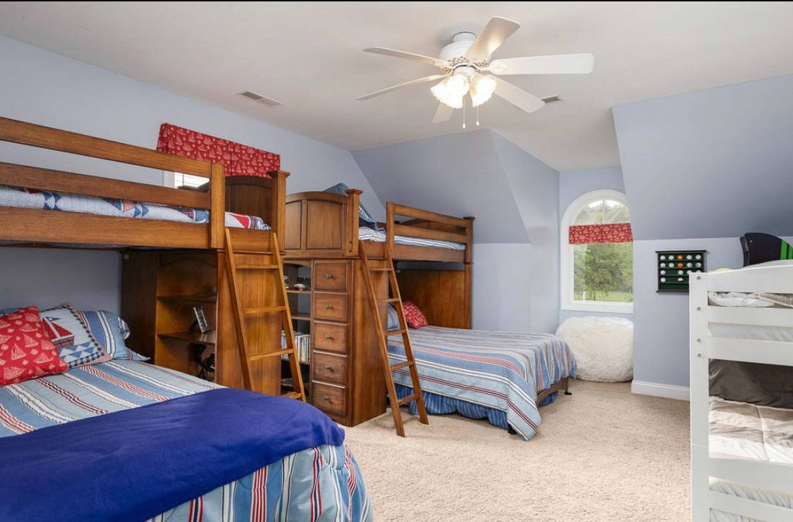 Bunk room with wooden bunk beds, built-in storage and blue walls