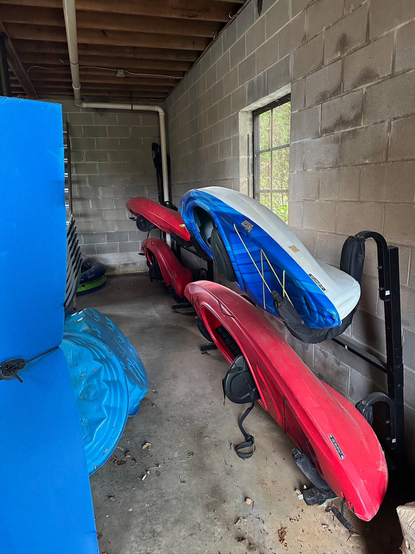 Kayaks and paddleboards racked inside the boathouse